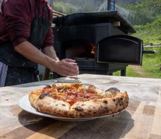 Pizza vor Holzbackofen