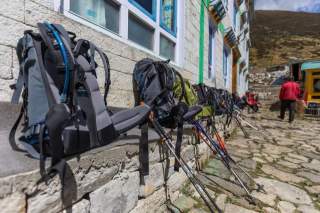 Rucksäcke aufgereiht vor einer Berghütte