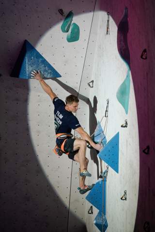Kletterer Christoph Hanke an Kletterwand im Spotlight