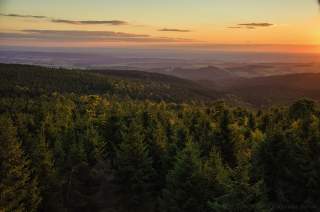 Stimmungsvolles Abendlicht über einem bewaldeten Mittelgebirge.