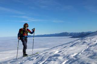 Bernhard Agerer über den Wolken, Aufstieg bei der Skidurchquerung. Strahlender Sonnenschein und blauer Himmel.