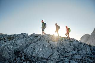 Gruppe von Bergsteier*innen bei Sonnenaufgang