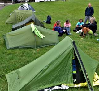Zelte auf Wiese, davor die Wandergruppe
