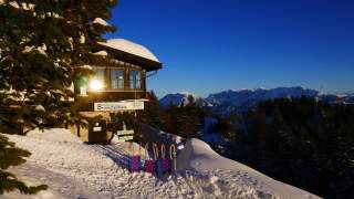Brünnsteinhaus im Winter mit Rodel vor der Tür