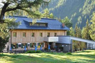 Hütte mit Blechdach und dem Schild 