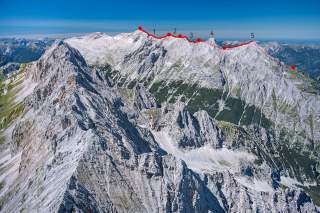Panoramablick auf eine Bergkette mit einer markierten Wanderroute in Rot, die über mehrere Gipfelpunkte führt, nummeriert von 1 bis 5.