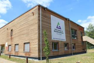 Modernes Gebäude mit Holzfassade und großem Banner 