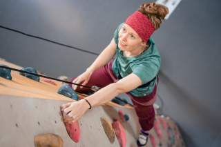Frau beim Klettern im Toprope