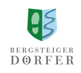 Logo mit einem geteilten Schild, links grün mit einem Fußabdruck und rechts blau mit einem geschwungenen Weg, darunter der Schriftzug „Bergsteiger Dörfer“.
