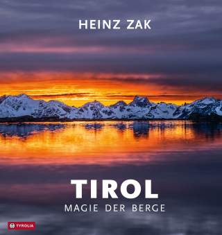 Schneebedeckte Berge spiegeln sich in einem ruhigen Gewässer bei einem farbenprächtigen Sonnenuntergang mit orange-lila Himmel. Über dem Bild steht der Name 