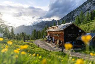 Hütte im Abendlicht im Gebirge mit Blick ins Tal