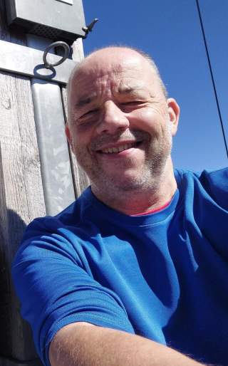 lächelnder Mann in blauem Oberteil