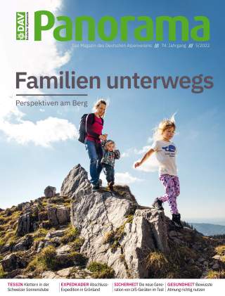 Eine Frau mit zwei Kindern wandert auf felsigem Gelände in den Bergen bei sonnigem Wetter mit blauem Himmel.