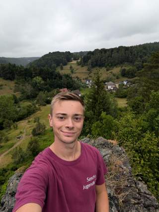 Lächelnder junger Mann in Bergen