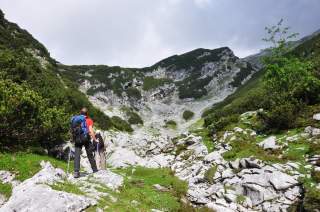 Menschen wandern in felsiger Berglandschaft.